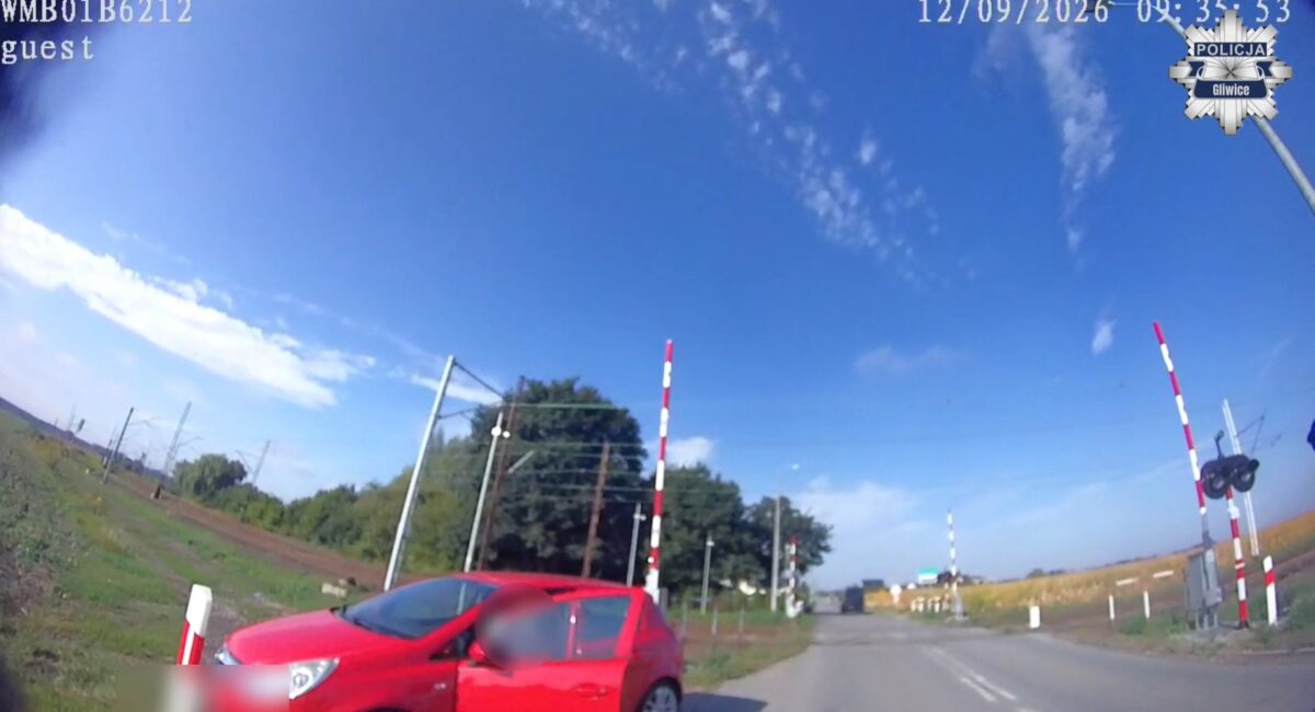 Czerwony Opel wjeżdżający na przejazd kolejowy przy czerwonym świetle w Gierałtowicach